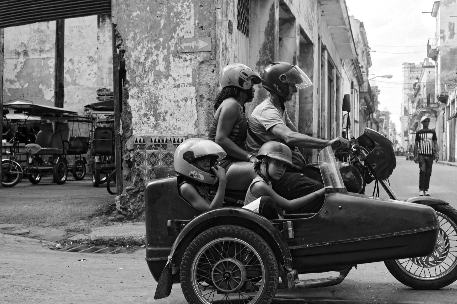 Famille casquée en side-car dans une rue de La Havane, photographie en noir et blanc
